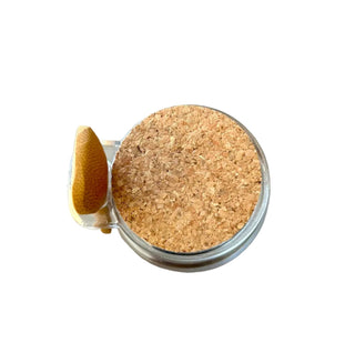 Small glass jar with cork lid on a concrete surface